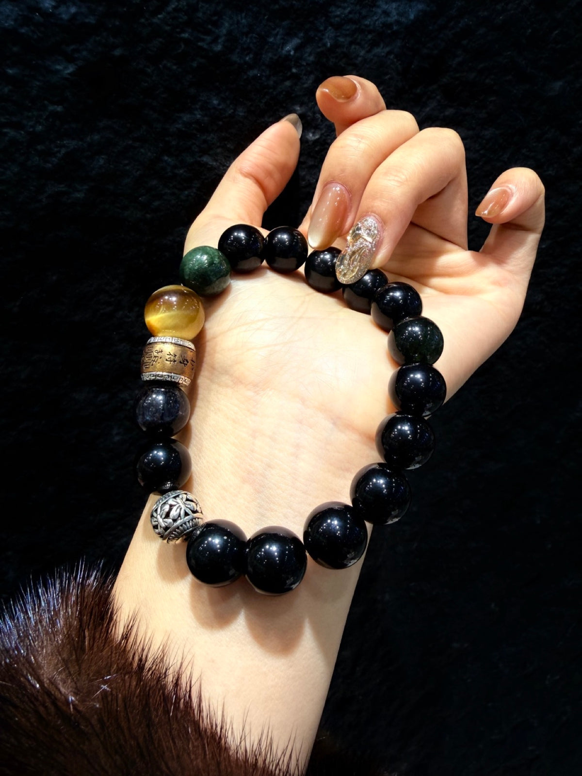 Obsidian Guardian Bracelet displayed in hand, blue tiger's eye and decorative spacer beads