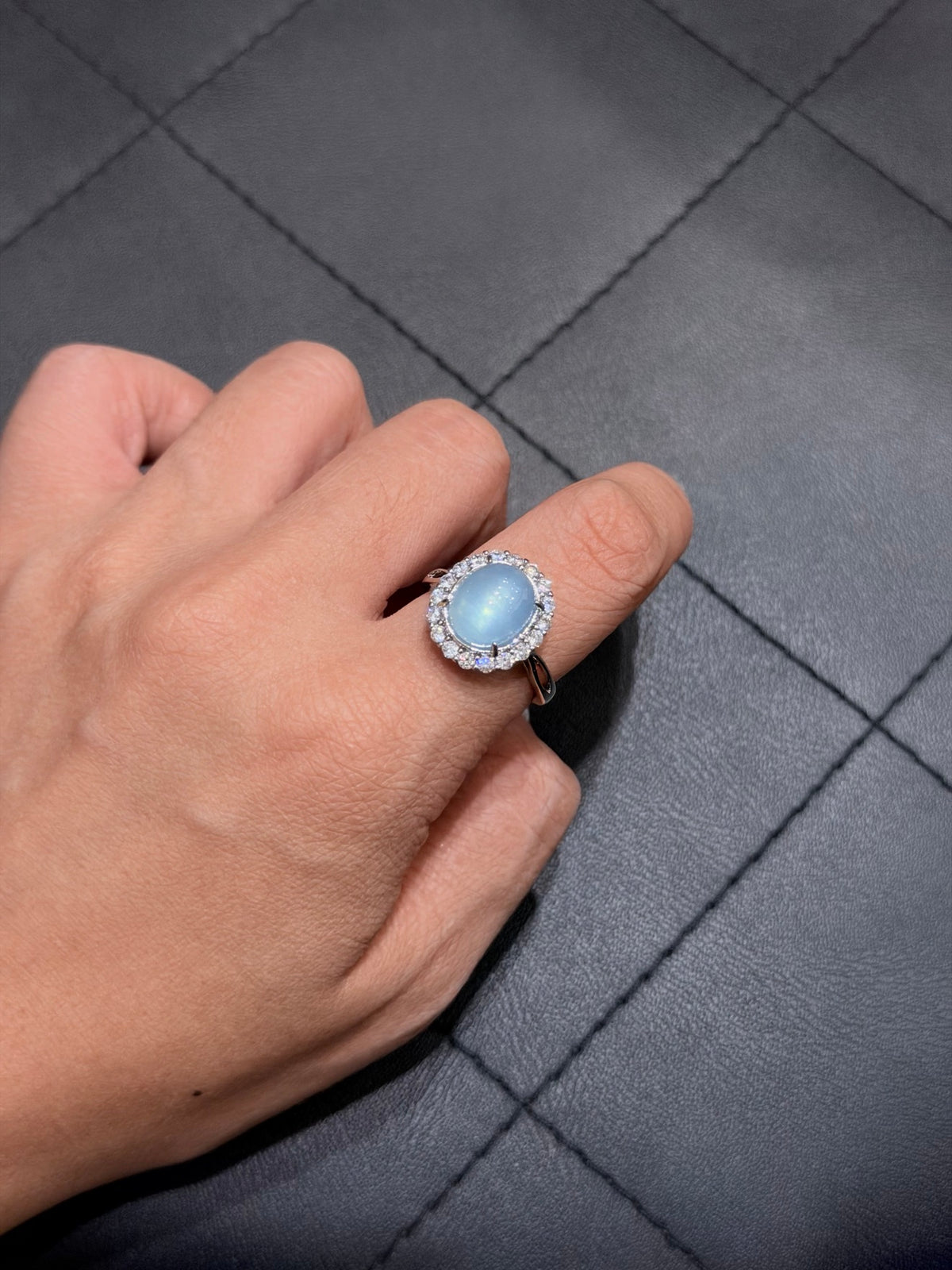 Glacier aquamarine halo ring with 18K gold plated setting worn on a finger