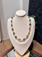 Smoky quartz beaded necklace displayed on a jewelry bust