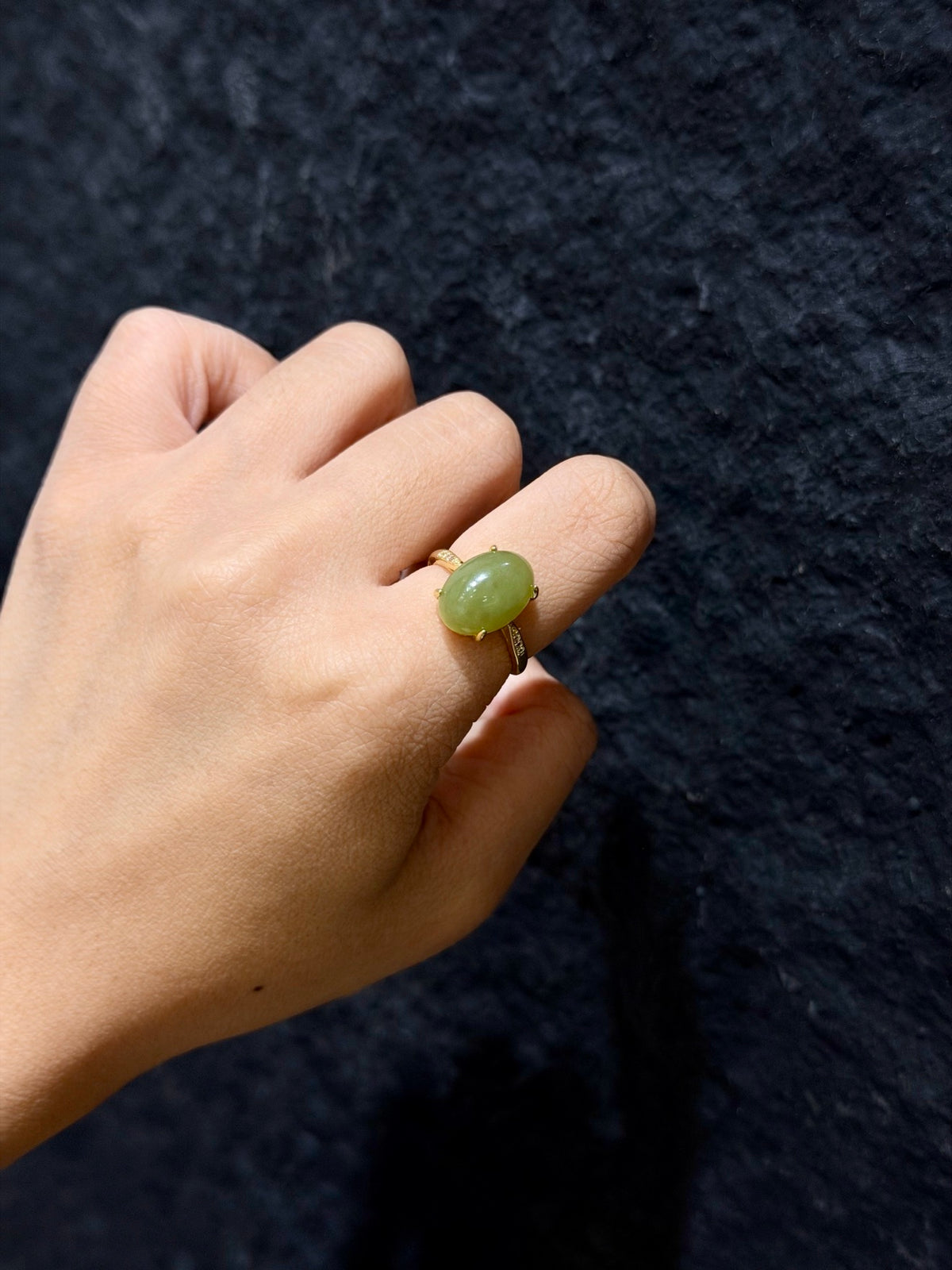 Hetian jade solitaire ring with 18K gold plated setting worn on a finger
