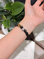 Black Gold Armor Bracelet worn on wrist, obsidian beads with skull charm