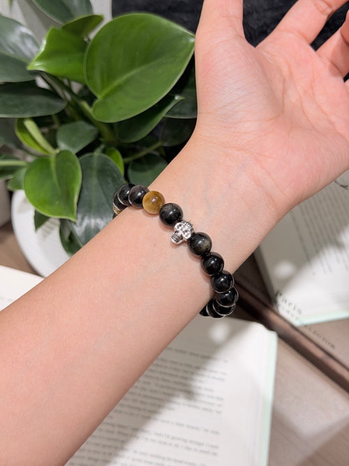Black Gold Armor Bracelet worn on wrist, obsidian beads with skull charm