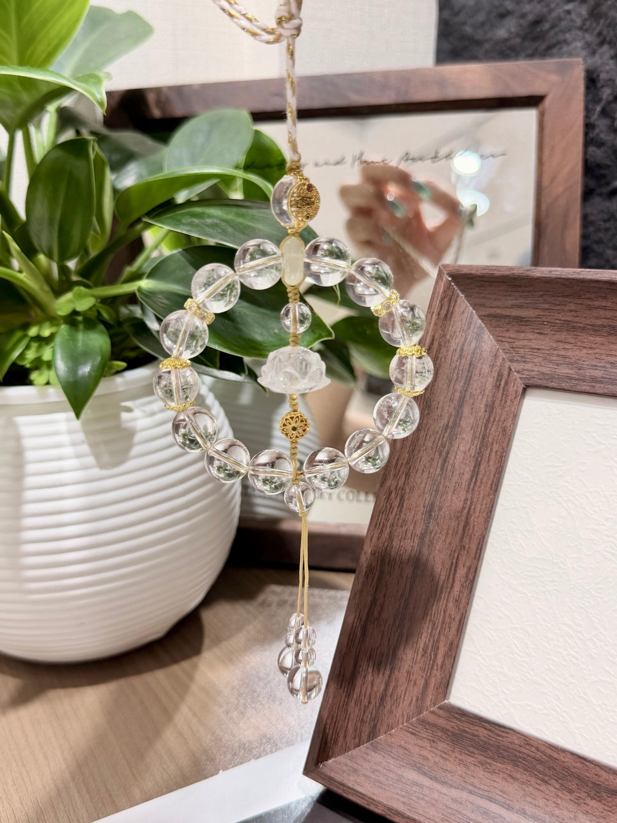 Clear quartz ring car charm with lotus carving on a magazine