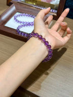 Regal Amethyst Bracelet held in hand showing premium translucent amethyst beads