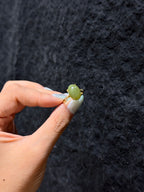 Oval Hetian jade cabochon ring held between fingers, close-up