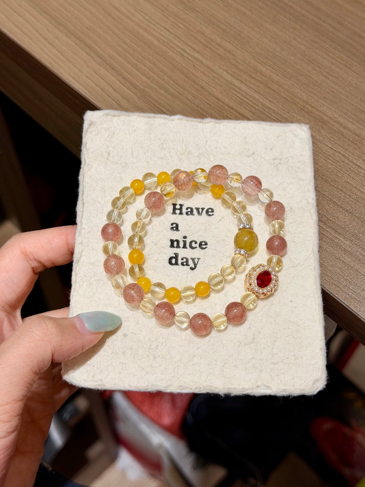 Honeyberry Gilt Bracelet on a 'Have a nice day' card, pink and yellow beads with red gemstone charm