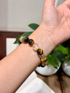 Golden Tiger Fortune Bracelet held in hand, tiger's eye beads with 18K gold plated mantra spacer beads