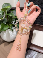 Clear quartz car charm held in a hand