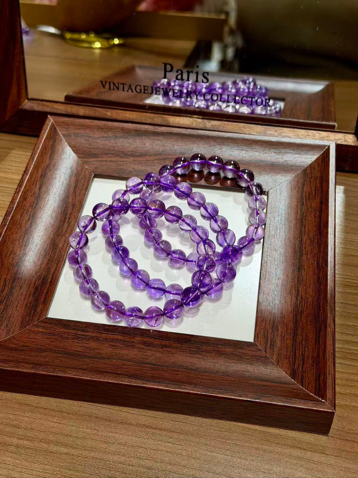 Regal Amethyst Bracelet coiled in a wooden tray, premium amethyst beads
