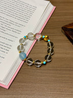 Clear quartz and aquamarine bracelet with magnesite beads on a book