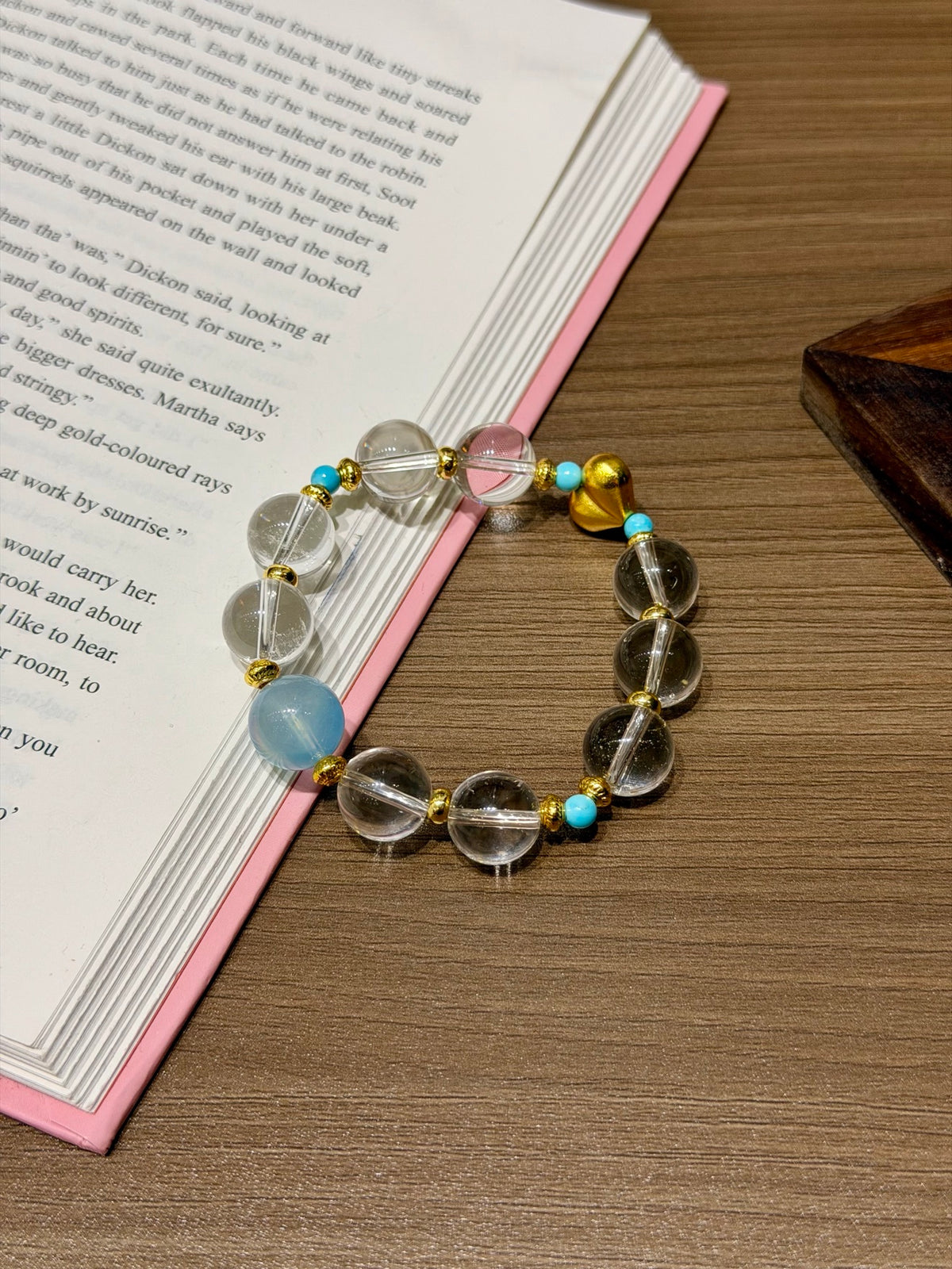 Clear quartz and aquamarine bracelet with magnesite beads on a book