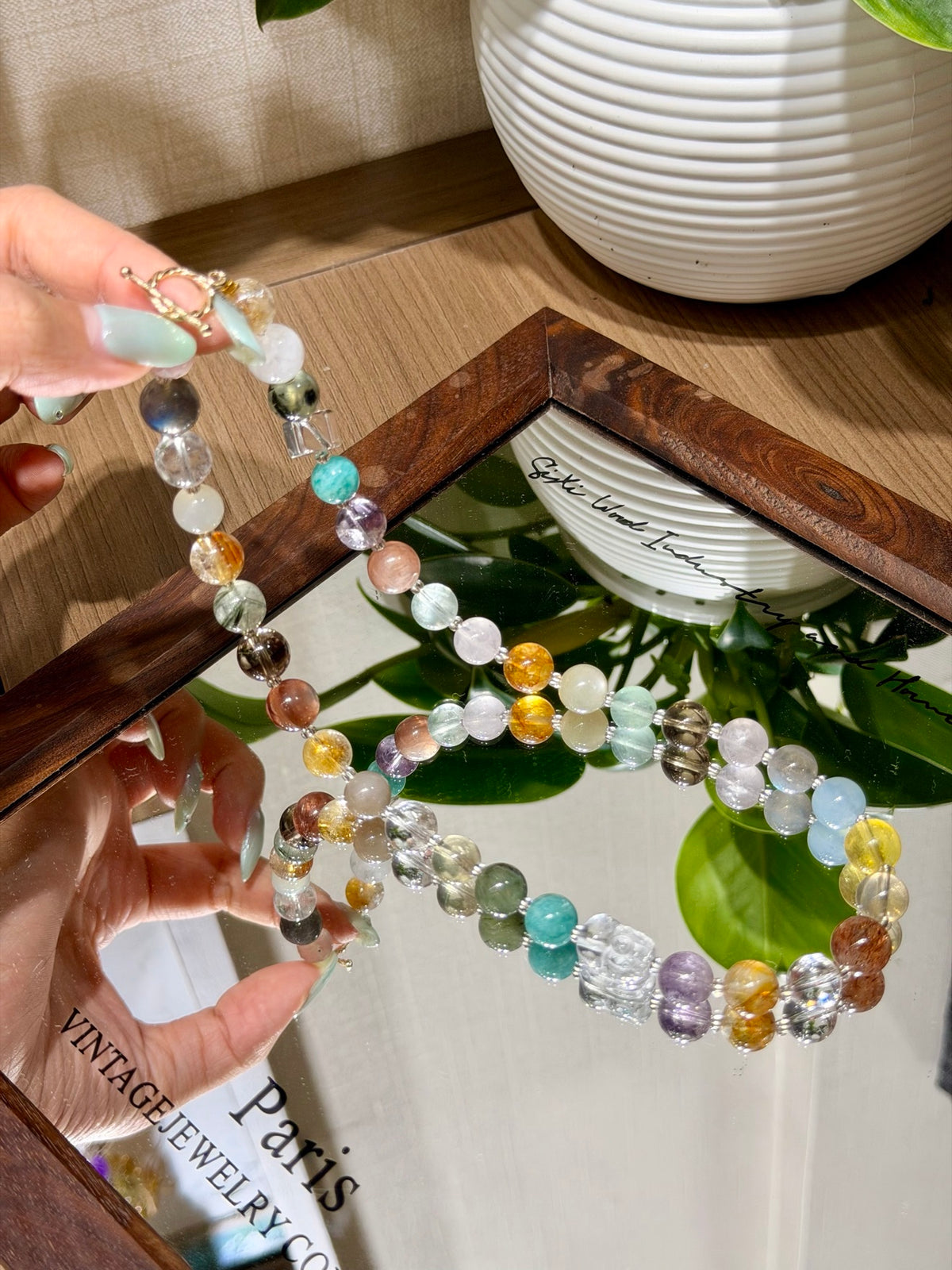 Multi-gemstone necklace with toggle clasp held in a hand