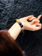 Obsidian Guardian Bracelet worn on wrist, black obsidian with tiger's eye and mantra beads