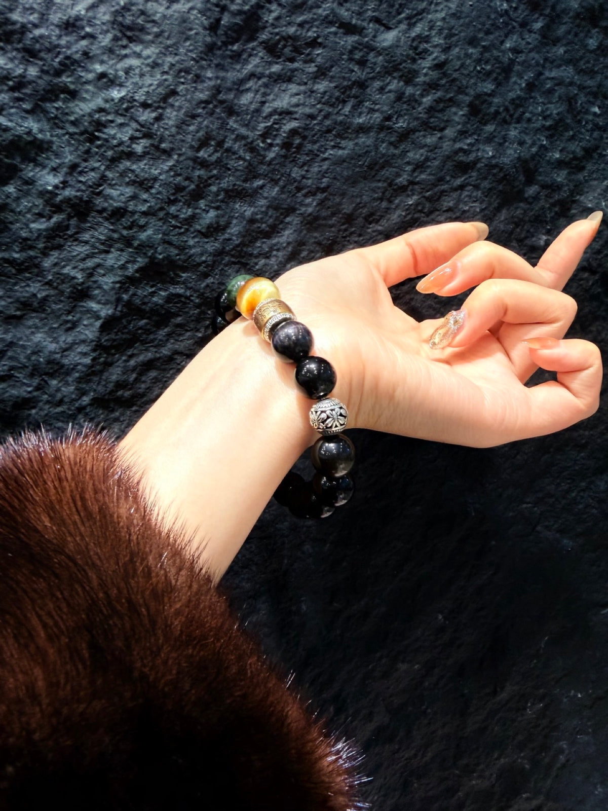 Obsidian Guardian Bracelet worn on wrist, black obsidian with tiger's eye and mantra beads