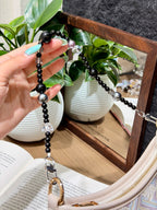 Obsidian bag charm with pearls over a mirror