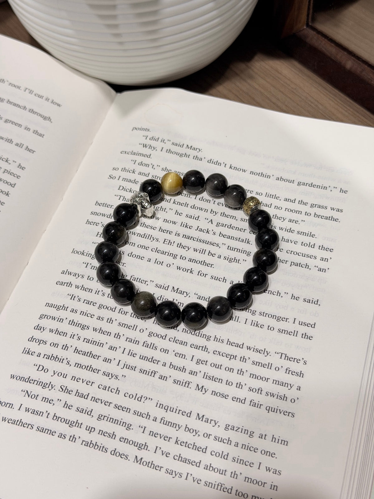 Black Gold Armor Bracelet held above the wrist, skull charm and gold accent bead