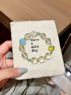 Aquamarine and clear quartz bracelet with gold heart on a card