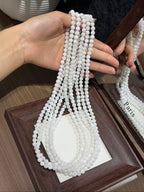 Snowfall Triple-Loop Bracelet strands held in hand, white snowflake phantom quartz beads