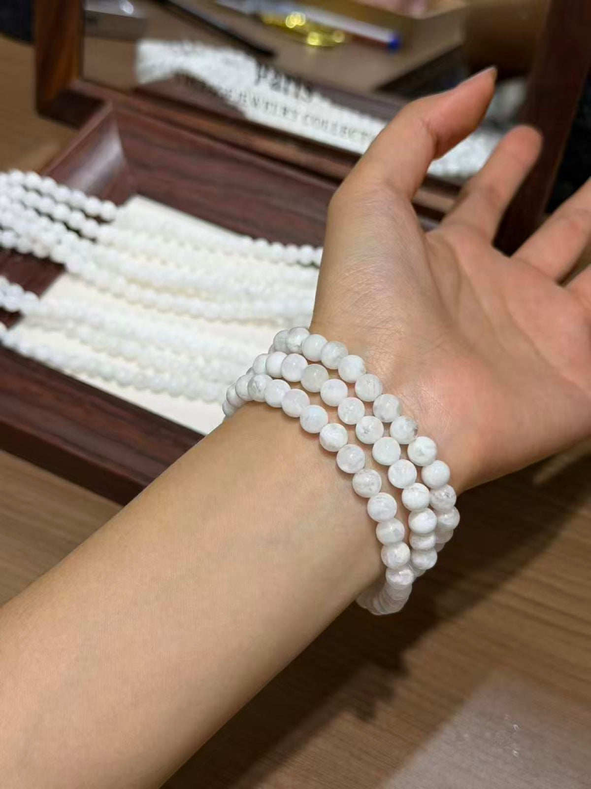Snowfall Triple-Loop Bracelet worn on wrist, triple wrap of translucent white beads