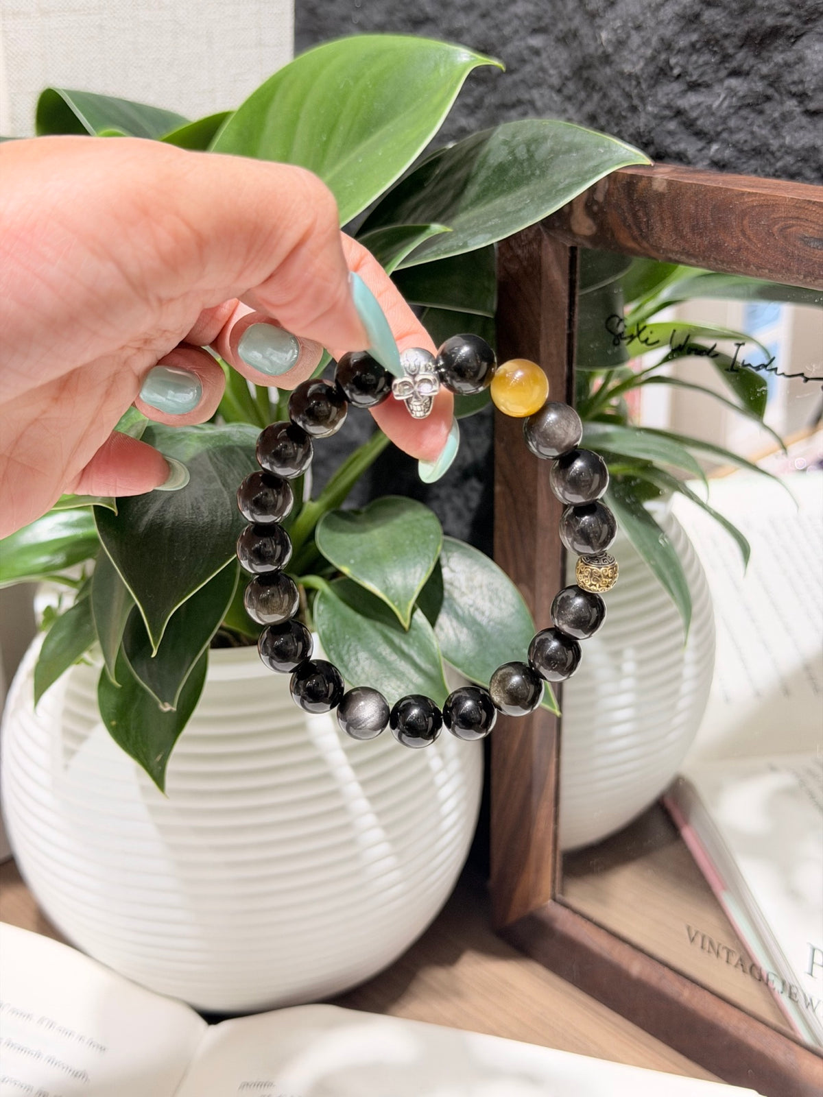 Black Gold Armor Bracelet resting on an open book, men's black and gold bracelet