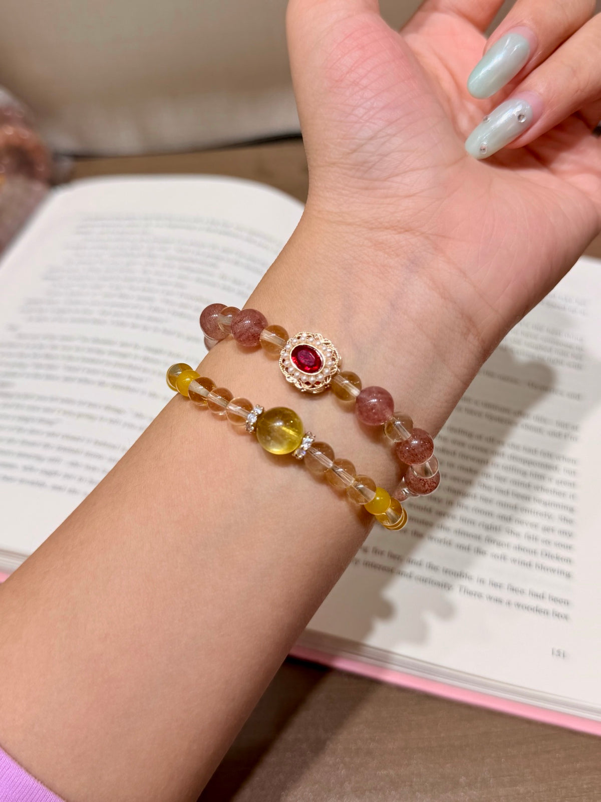 Honeyberry Gilt Bracelet worn on wrist, double-loop with gold-set red gemstone charm