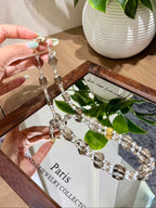 Smoky quartz necklace with faceted beads held in a hand