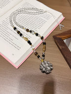 Silver sheen obsidian fox pendant necklace laid on an open book