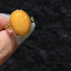 Close-up of oval beeswax amber cabochon in 18K gold plated bezel setting