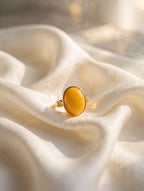 Honey amber solitaire ring styled on cream silk fabric