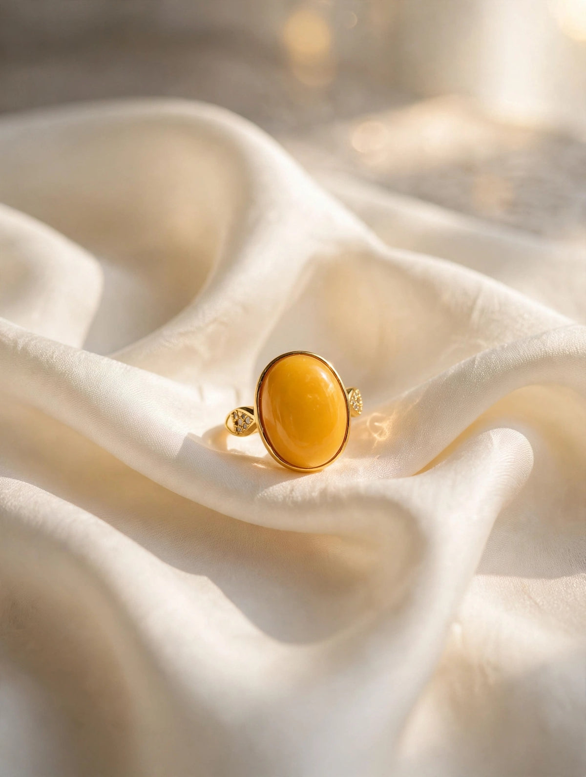 Honey amber solitaire ring styled on cream silk fabric